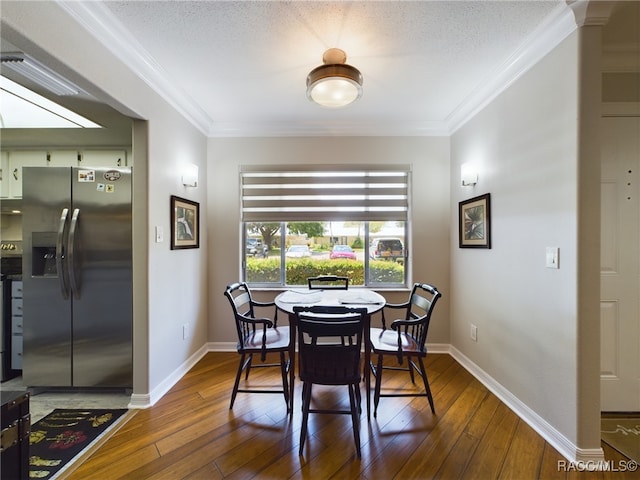 dining room featuring crown molding, dark wood-type flooring, and a textured ceiling