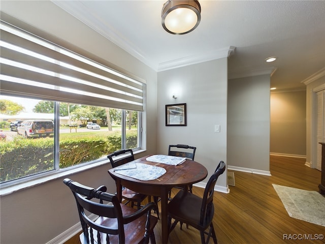 dining area featuring crown molding and dark wood-type flooring