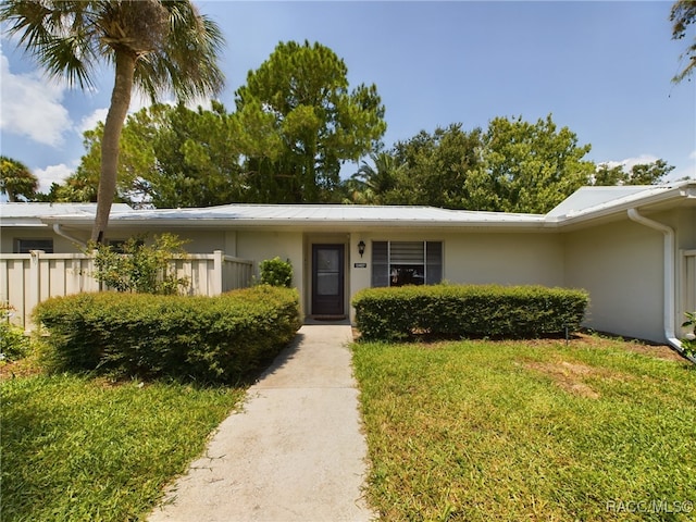 single story home with a front lawn