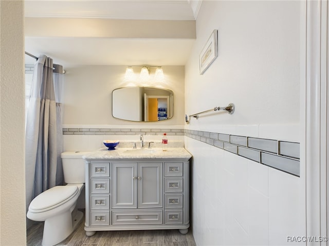 bathroom with vanity, toilet, wood-type flooring, and tile walls