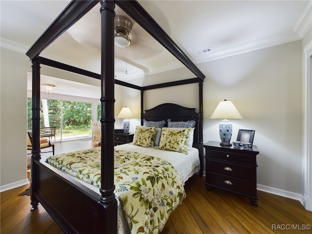 bedroom with dark hardwood / wood-style flooring, ceiling fan, and crown molding