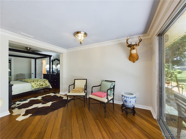 living area featuring hardwood / wood-style floors and ornamental molding