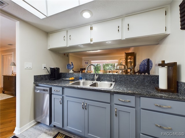 kitchen featuring stainless steel dishwasher, crown molding, sink, light hardwood / wood-style flooring, and white cabinets