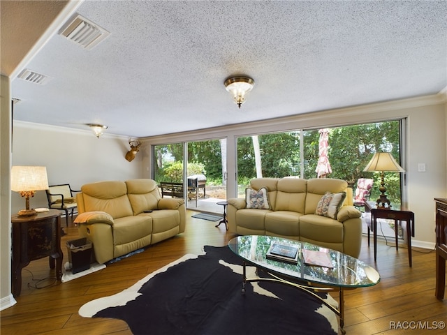 living room with a textured ceiling, hardwood / wood-style flooring, and crown molding