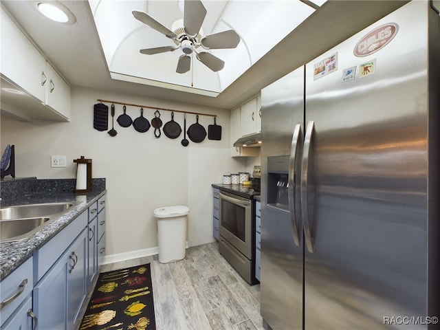 kitchen featuring sink, light wood-type flooring, blue cabinetry, appliances with stainless steel finishes, and white cabinetry