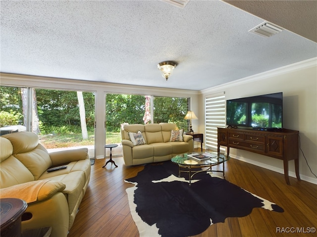 living room with a wealth of natural light, dark hardwood / wood-style flooring, crown molding, and a textured ceiling