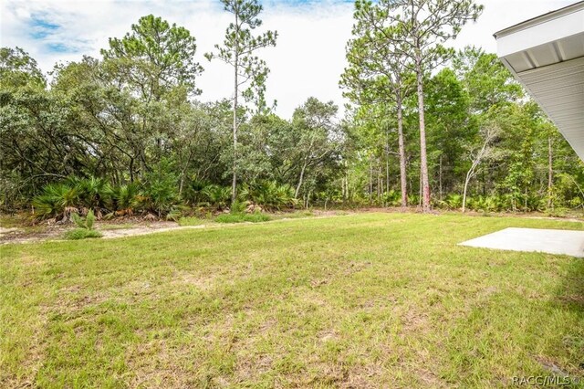 back of property featuring a patio area and a lawn