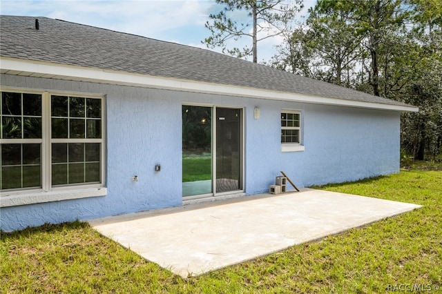 back of property featuring a lawn and a patio