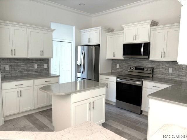4496 N Elkcam Blvd, Beverly Hills, FL 34465 - kitchen featuring appliances with stainless steel finishes, ornamental molding, light wood-type flooring, backsplash, and white cabinetry