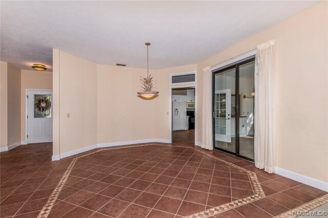 spare room featuring dark tile patterned flooring