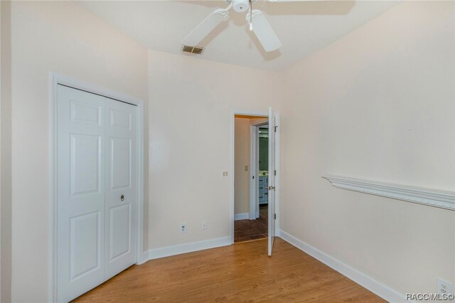 unfurnished bedroom featuring ceiling fan, light wood-type flooring, and a closet