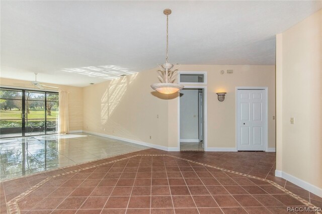 tiled empty room featuring ceiling fan