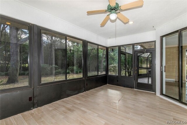 unfurnished sunroom with ceiling fan