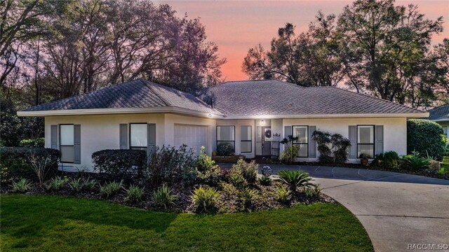 ranch-style house with a garage and a front yard