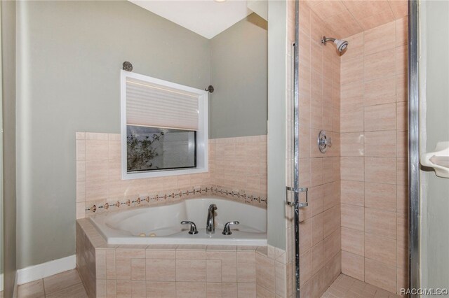 bathroom with tile patterned flooring and shower with separate bathtub