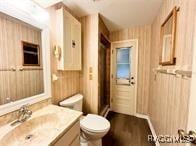 21389 SW 102cd St, Dunnellon, FL 34431 - bathroom featuring vanity, toilet, and wood walls