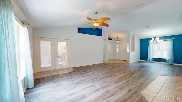 unfurnished living room featuring a healthy amount of sunlight, french doors, wood-type flooring, and vaulted ceiling