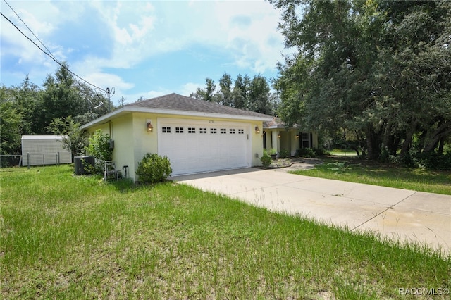 view of front of home with a front yard, central AC, and a garage