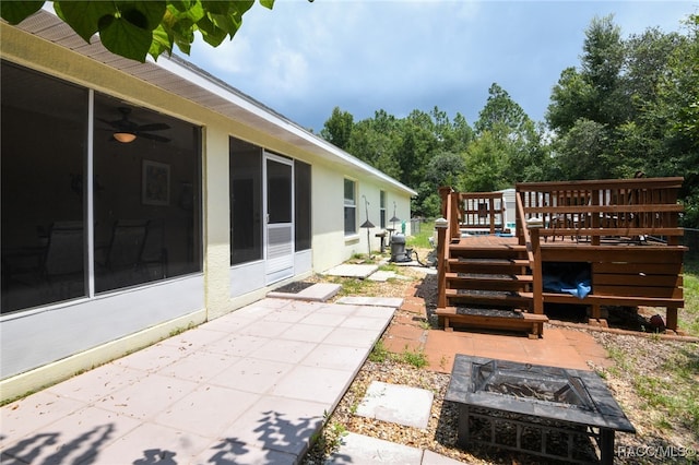 view of yard with a sunroom, a patio area, a deck, and an outdoor fire pit