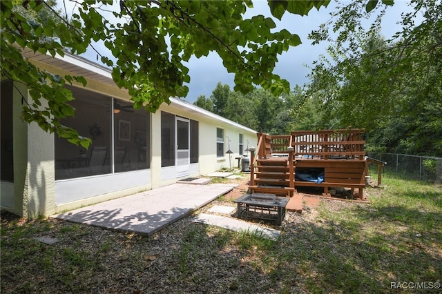 view of yard with a sunroom, a patio area, and a wooden deck