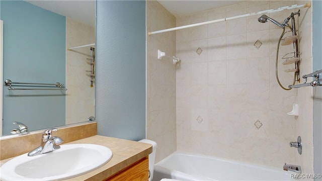 full bathroom with vanity, tiled shower / bath combo, and toilet