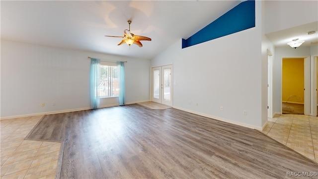 spare room with ceiling fan, french doors, high vaulted ceiling, and light hardwood / wood-style flooring