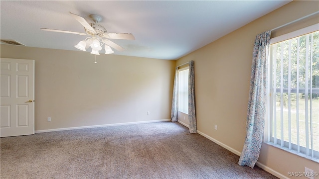 carpeted spare room with ceiling fan