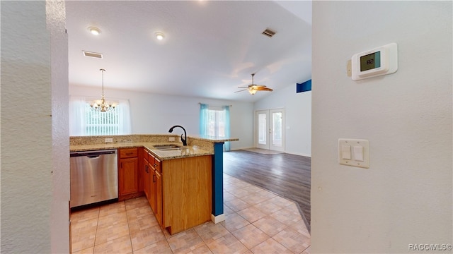 kitchen with dishwasher, lofted ceiling, ceiling fan with notable chandelier, sink, and kitchen peninsula