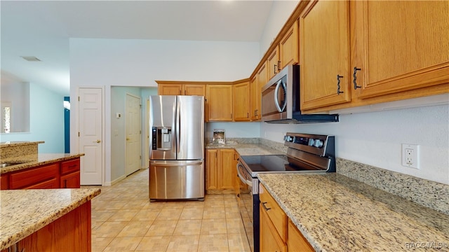 kitchen with light tile patterned floors, stainless steel appliances, and light stone counters