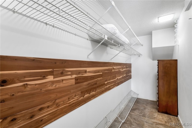 spacious closet featuring stone finish floor