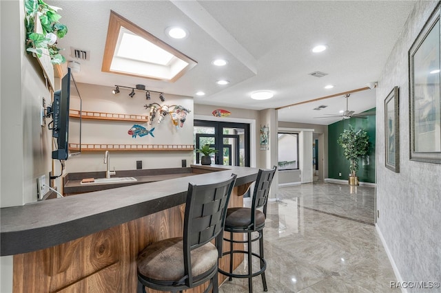 bar featuring visible vents, baseboards, indoor wet bar, a sink, and marble finish floor