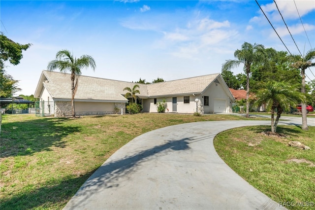 single story home with concrete driveway, a front yard, stucco siding, and a garage