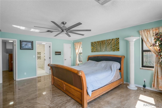 bedroom with a textured ceiling, ceiling fan, ensuite bath, and visible vents