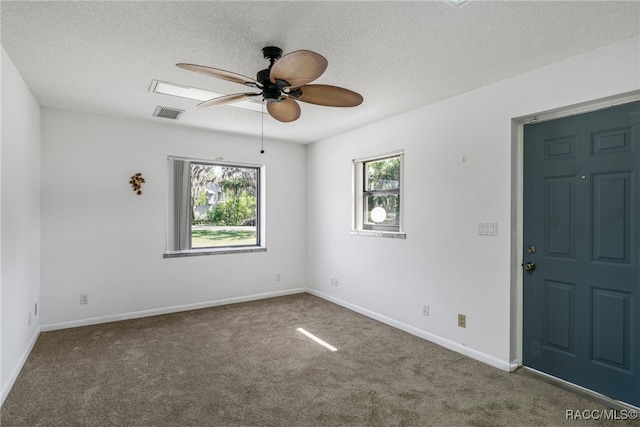spare room with baseboards, a ceiling fan, carpet, and a textured ceiling