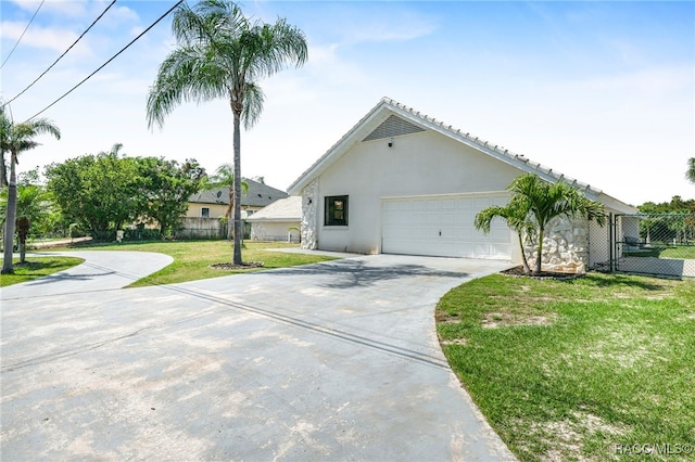 view of front of home featuring an attached garage, concrete driveway, fence, stucco siding, and a front lawn