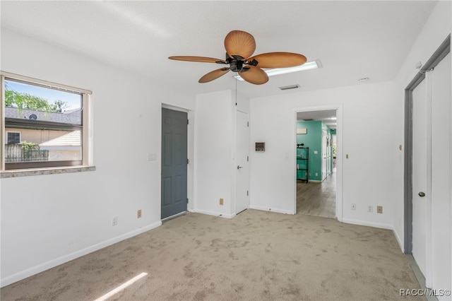 unfurnished bedroom with baseboards, a ceiling fan, visible vents, and carpet floors