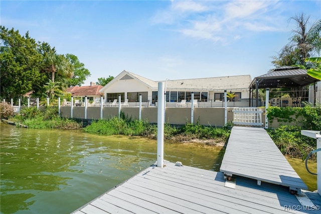 dock area with fence and a water view