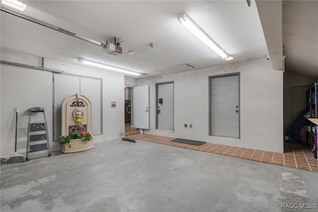 garage with a garage door opener and washer / dryer