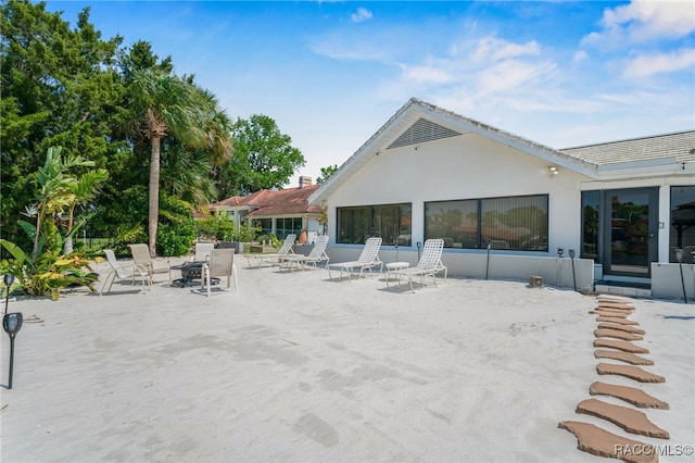 rear view of property with a patio area and stucco siding