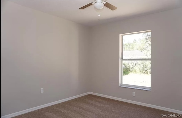 carpeted spare room featuring ceiling fan