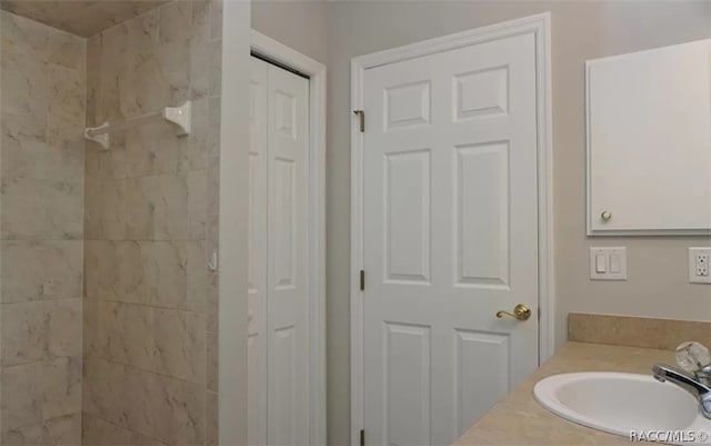 bathroom featuring a tile shower and vanity