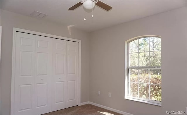 unfurnished bedroom featuring carpet flooring, ceiling fan, and a closet