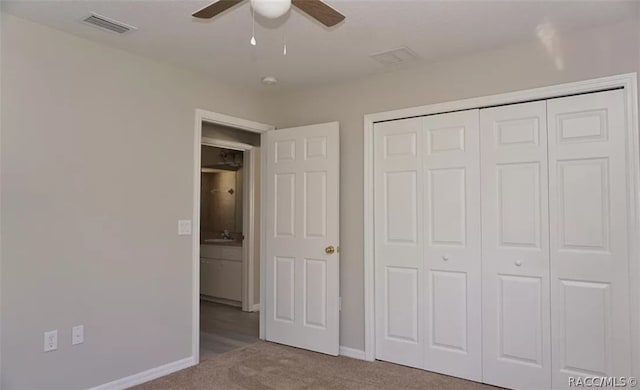 unfurnished bedroom featuring ceiling fan, light carpet, and a closet