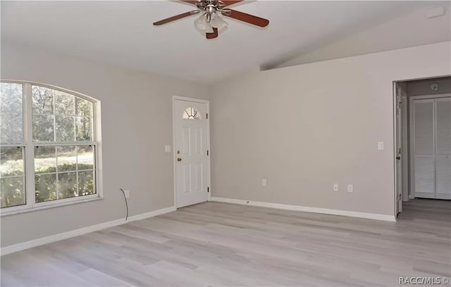 spare room featuring ceiling fan, lofted ceiling, and light hardwood / wood-style flooring