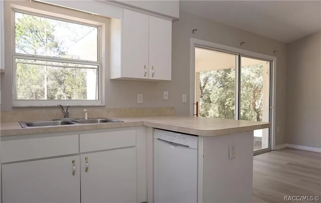 kitchen featuring white dishwasher, white cabinetry, and a healthy amount of sunlight