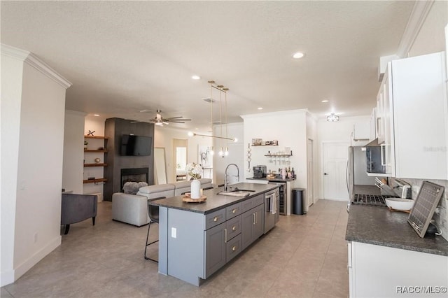 kitchen featuring sink, gray cabinets, a breakfast bar area, white cabinetry, and decorative light fixtures