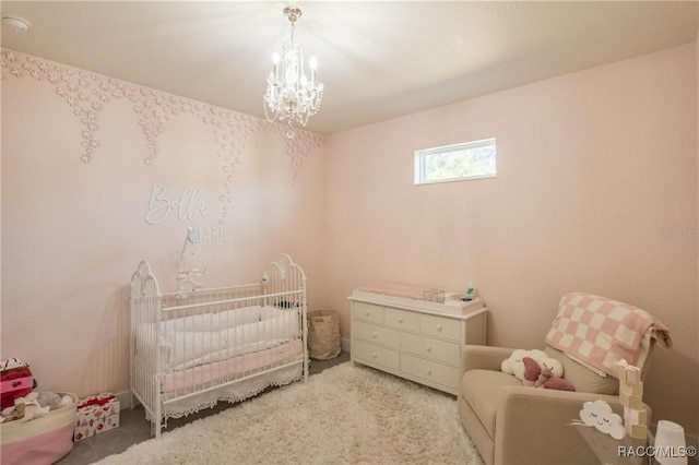 carpeted bedroom featuring a nursery area and an inviting chandelier