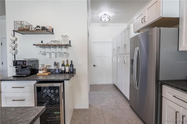 kitchen featuring wine cooler, white cabinetry, crown molding, light tile patterned floors, and stainless steel fridge