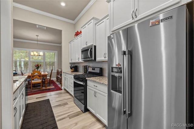 kitchen with white cabinetry, appliances with stainless steel finishes, light stone countertops, and hanging light fixtures