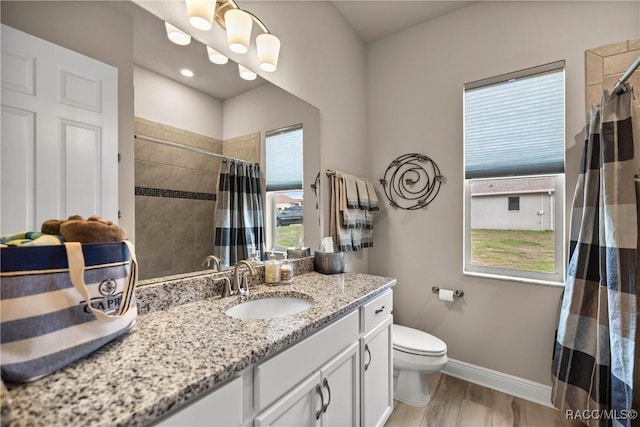 bathroom featuring hardwood / wood-style flooring, vanity, toilet, and walk in shower